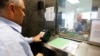 FILE PHOTO - A man has his fingerprints electronically taken while taking part in a visa application demonstration during a media tour at the consular section of the Embassy of the United States.
