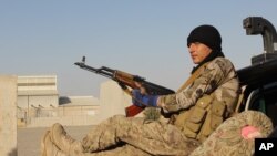 An Afghan National Army soldier rests after he arrives in a camp outside Kunduz city, north of Kabul, Afghanistan, Sept. 30, 2015.