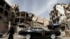 A woman walks past a vehicle parked near damaged buildings in Douma, in the eastern suburbs of Damascus, March 9, 2021. (Omar Sanadiki /Reuters) 