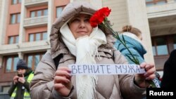 The wife of a mobilized Russian serviceman joins with other wives to demand the return of their husbands from Ukraine front, in Moscow, Feb. 3, 2024.