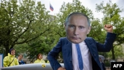 FILE - An activist wearing a mask of Russia's President Vladimir Putin stands in front of a mockup of a nuclear bomb during a demostration for the abolition of nuclear weapons in front of the Russian embassy in Berlin on June 23, 2023.