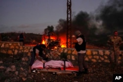 FILE - Petugas dari Pertahanan Sipil memindahkan jenazah videografer Reuters Issam Abdallah yang terbunuh oleh serangan Israel, di desa perbatasan Alma al-Shaab dengan Israel, Lebanon selatan, Jumat, 13 Oktober 2023. (AP/Hassan Ammar)