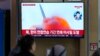 FILE - A TV screen shows a file photo of a North Korean missile launch during a news program, at the Seoul Railway Station in Seoul, South Korea, March 22, 2023. 
