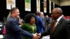 FILE - South African President Cyril Ramaphosa, right, greets opposition Democratic Alliance (DA) leader, John Steenhuisen, left, at the first sitting of Parliament since elections, in Cape Town, June 14, 2024. 