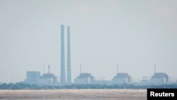 FILE: Pemandangan Pembangkit Listrik Tenaga Nuklir Zaporizhzhia dari tepi Waduk Kakhovka dekat kota Nikopol setelah bendungan Nova Kakhovka jebol, di tengah serangan Rusia ke Ukraina, di wilayah Dnipropetrovsk, Ukraina 16 Juni 2023. (REUTERS/Alina Smutko)
