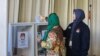 Seorang anggota KPPS) di TPSLN Las Angeles membantu pemilih memasukkan surat suara ke kotak suarai, Sabtu, 10 Februari 2024. Para pemilih di luar negeri hanya bisa memilih calon presiden/calon wakil dan calon anggota legislatif (caleg) DPR RI. (Foto: Rivan Dwiastono/VOA)