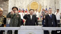 FILE - North Korea's Kim Jong Un, center, Russian Defense Minister Sergei Shoigu, left, and Chinese Communist Party politburo member Li Hongzhon attend a military parade to mark the 70th anniversary of the Korean War armistice, in Pyongyang, North Korea, July 27, 2023.