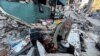 Perempuan Palestina Umm Nael Al-Khlout memasak sarapan di atas puing-puing rumahnya yang hancur akibat serangan militer Israel, di Beit Lahia, Jalur Gaza utara, 13 Maret 2024. (REUTERS/Mahmoud Issa)
