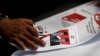 Seorang pekerja menggunakan kaca pembesar saat memeriksa surat suara yang dicetak untuk pemilihan presiden di sebuah pabrik di Jakarta, 20 Januari 2019. (Foto: REUTERS/Willy Kurniawan)