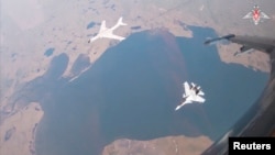 Pesawat pembom H-6K milik Angkatan Udara Tentara Pembebasan Rakyat China (PLA) dan jet tempur Sukhoi Su-30CM Rusia dalam patroli pesawat militer gabungan Rusia-China di dekat negara bagian Alaska, AS, 25 Juli 2024. (Kementerian Pertahanan Rusia/Handout via REUTERS)