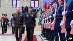 Menteri Pertahanan Rusia Sergei Shoigu (kiri) dan Menteri Pertahanan China Jenderal Li Shangfu menghadiri sebuah acara di Moskow, pada 18 April 2023. (Foto: Russian Defense Ministry Press Service photo via AP)