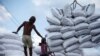 Seorang buruh berdiri di dekat karung-karung pupuk di Pelabuhan Sunda Kelapa, Jakarta. (Foto: REUTERS/Beawiharta)