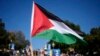 Seorang pengunjuk rasa mengibarkan bendera nasional Palestina dalam aksi pro Palestina di kampus UCLA di Los Angeles, AS (foto: ilustrasi). 