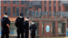 Para petugas keamanan berjaga di depan Institut Virologi Wuhan di Wuhan, Hubei, China, ketika sejumlah anggota WHO mengunjungi lembaga tersebut pada 3 Februari 2021. (Foto: Reuters/Thomas Peter)