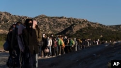 FILE - Chinese migrants wait to be processed after crossing the border with Mexico, May 8, 2024, near Jacumba Hot Springs, Calif.