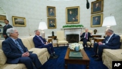 FILE - Sen. Mitch McConnell of Ky., Speaker of the House Kevin McCarthy of Calif., and Sen. Chuck Schumer of N.Y., listen to President Joe Biden in the Oval Office, May 9, 2023.