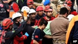 Rescue workers carry a girl pulled out from a collapsed building to an ambulance, in Malatya, Turkey, Feb. 27, 2023. A magnitude 5.6 earthquake shook southern Turkey on Monday. 