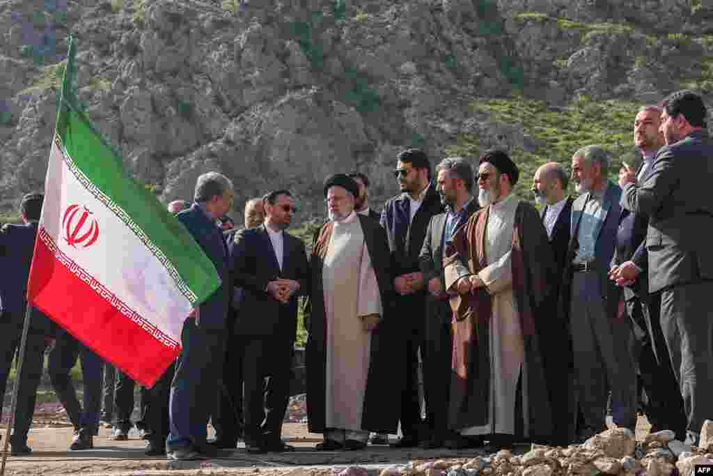A handout picture provided by the Iranian presidency shows Iran&#39;s President Ebrahim Raisi (C) at the site of Qiz Qalasi, the third dam jointly built by Iran and Azerbaijan on the Aras River, ahead of its inauguration ceremony, May 19, 2024.