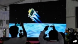 Journalists film the live telecast of spacecraft Chandrayaan-3 landing on the moon at ISRO's Telemetry, Tracking and Command Network facility in Bengaluru, India, Aug. 23, 2023. 