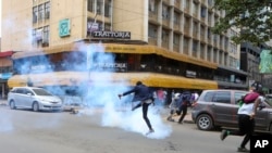 A demonstrator kicks back a tear gas canister during a protest against proposed tax hikes in a finance bill that is due to be tabled in parliament in Nairobi, Kenya, June 18, 2024.