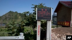 FILE - A sign warning against harboring people who cross the border is displayed near Lingjiang, on the border with North Korea, in northeastern China's Jilin province, Aug. 30, 2017. Beijing has reportedly repatriated hundreds of defectors from North Korea.
