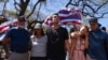 Community organizer Tiare Lawrence, second from right, is comforted by Archie Kalepa as they sing a song during a news conference with Lahaina, Hawaii, residents affected by the deadly wildfire in Lahaina, Aug. 18, 2023.