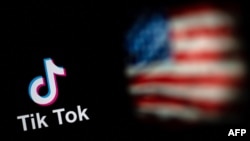 Logo aplikasi jejaring sosial TikTok (kiri) dan bendera AS (kanan) ditampilkan di layar dua laptop di Beijing. (Foto: AFP)