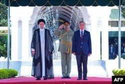 Presiden Rans Ebrahim Raisi (kiri) memeriksa pengawal kehormatannya bersama dengan Perdana Menteri Pakistan Shehbaz Sharif, di Islamabad, 22 April tiba di Islamabad. (Foto: via AFP)