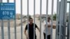 FILE - This picture taken on July 19, 2023, shows men at the gates of a Uyghur cemetery in Yengisar in northwest China's Xinjiang region.