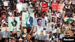People and families of the victims of Aug. 4, 2020, Beirut port blast carry their pictures during a march as Lebanon marks the three-year anniversary of the explosion in Beirut, Lebanon, Aug. 4, 2023. To date, no one has been held to account for the explosion.