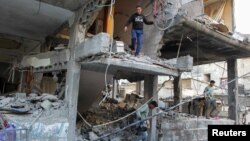 Des Palestiniens quittent une maison touchée par une frappe israélienne, à Rafah, dans le sud de la bande de Gaza, le 9 mai 2024. (REUTERS/Hatem Khaled)