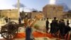 Seorang pria berswafoto saat pejabat kota Tripoli bersiap untuk menembakkan meriam Iftar menandai waktu untuk berbuka puasa di Martyrs Square, di ibu kota Libya, Tripoli, pada hari pertama bulan suci Ramadan, 23 Maret 2023. (Mahmud Turkia/AFP)