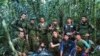 In this photo released by Colombia's Armed Forces Press Office, soldiers and Indigenous men pose for a photo with the four Indigenous brothers who were missing after a deadly plane crash, in the Solano jungle, Caqueta state, Colombia, June 9, 2023. 