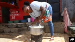 FILE - Mercy Letting, 33, prepares a meal outside her restaurant in Nairobi, Kenya, May 21, 2024.
