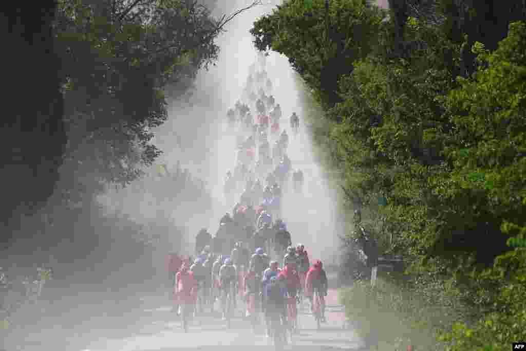 Rombongan pesepeda melintasi jalan putih Tuscany pada etape ke-6 lomba balap sepeda Giro d&#39;Italia ke-107, 180 kilometer antara Torre del lago Puccini dan Rapolano Terme, Italia.