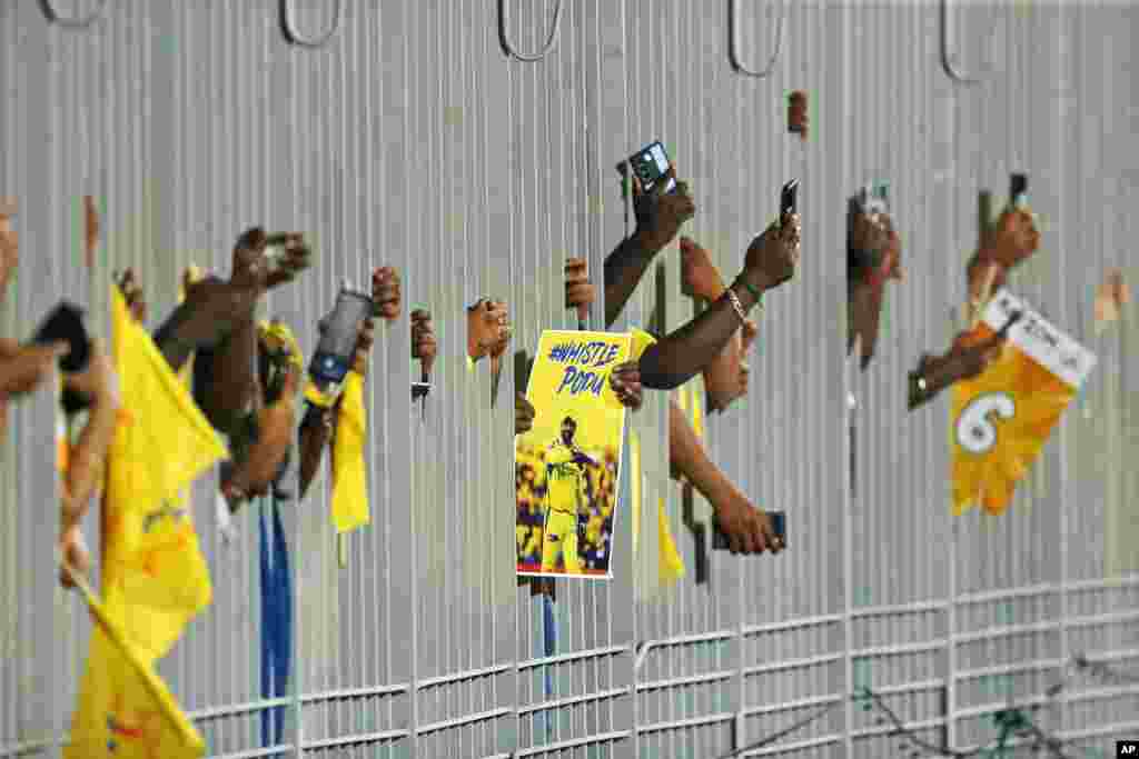 Para fans membawa poster MS Dhoni dari Chennai Super Kings dan memotret melalui pagar sambil menunggu dimulainya pertandingan kriket Liga Utama India antara Chennai Super Kings dan Punjab Kings di Chennai, 1 Mei 2024.&nbsp;(AP/R.Parthibhan)