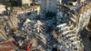 FILE - Rescue teams search for people as cranes remove debris from destroyed buildings in Antakya, southeastern Turkey, Feb. 10, 2023.
