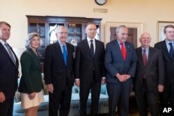 Polish President Andrzej Duda, center, is welcomed for talks with Senate Minority Leader Mitch McConnell, center left, and Senate Majority Leader Chuck Schumer, center right, and other senators at the Capitol in Washington, March 12, 2024.