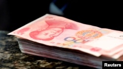 Pecahan uang 100 yuan terlihat di sebuah konter bank komersial di Beijing, pada 30 Maret 2016. (Foto: Reuters/Kim Kyung-Hoon)