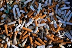 Puntung rokok memenuhi wadah rokok di luar gedung federal di Washington, Kamis, 15 April 2021.(Foto: AP)