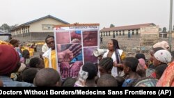 FILE - This photo supplied by Doctors Without Borders shows health workers educating children in Goma, Congo, about the symptoms of mpox disease, May 31, 2023.