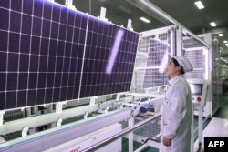 FILE - An employee works on solar photovoltaic modules that will be exported at a factory in Lianyungang, in China's eastern Jiangsu province, Jan. 4, 2024.