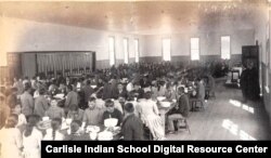 ภาพนักเรียนนั่งรับประทานอาหารในโรงเรียนกินนอน Carlisle Indian Boarding School เมื่อช่วงปี 1880-1889