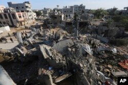 Palestinians look at the destruction by the Israeli bombardment of the Gaza Strip in Rafah, Dec. 4, 2023.