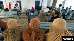 FILE - Afghan women refugees living in Pakistan wait to get registered at an office in Peshawar, Pakistan, Sept. 30, 2021.