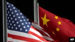 FILE - The U.S. and Chinese flags wave in Zhangjiakou, China, Feb. 2, 2022. The U.S. State Department recently modified its online fact sheet on China, dropping the country’s official name in favor of just using China.