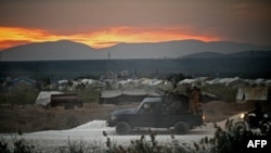 FILE - Members of the Hayat Tahrir al-Sham jihadist group advance towards the village of Jindayris in the Afrin region of Syria's rebel-held northern Aleppo province, Oct. 12, 2022.