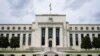 FILE - An American flag flies over the Federal Reserve Board Building in Washington, May 4, 2021.