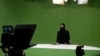 Masheed Barzz, seorang presenter untuk stasiun televisi 1TV, tambil dengan penutup wajah saat melakukan siaran di Kabul, Afghanistan, pada 25 Mei 2022. (Foto: AFP/Wakil Kohsar)