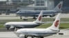 资料照- 三架中国国航（Air China）班机停在北京机场的跑到上等待进港或起飞。
